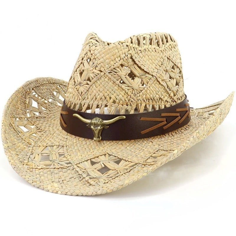A straw cowboy hat with a bull skull emblem on a brown leather band.
