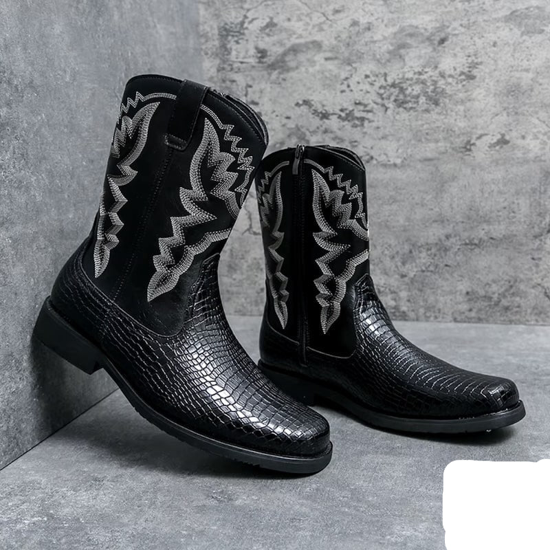 Two black, mid-calf cowboy boots with textured leather and embroidered detailing against a gray background.