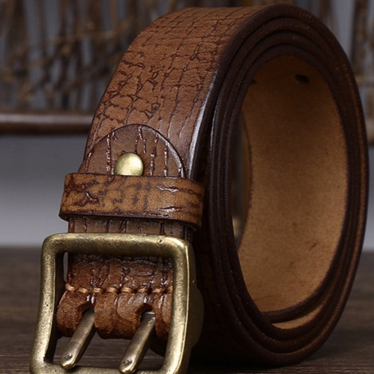 Close-up of a brown, leather belt with a brass buckle.