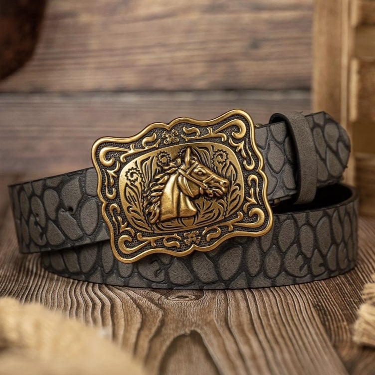 Close-up of a gray belt with a gold horse buckle on a wooden surface.
