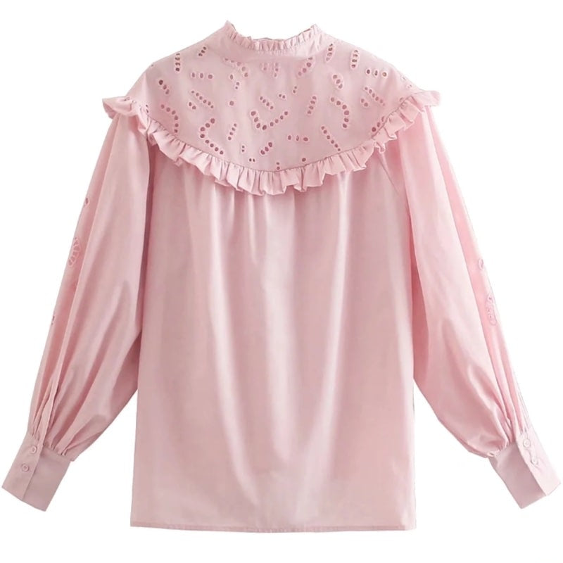 Pink blouse with ruffle collar and eyelet details.
