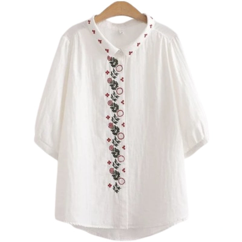 White embroidered cotton blouse on hanger.