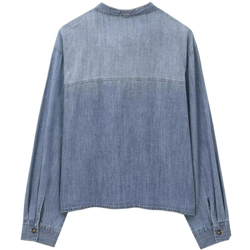 Back of a blue denim shirt with long sleeves.