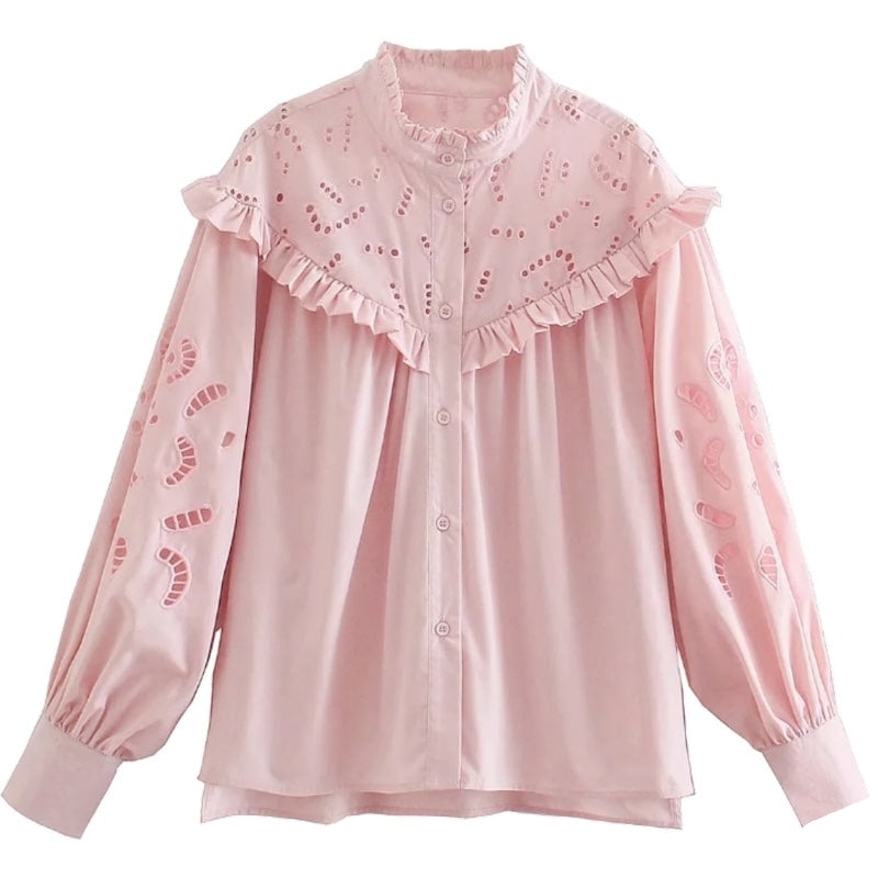 Pink blouse with ruffles and eyelet details.