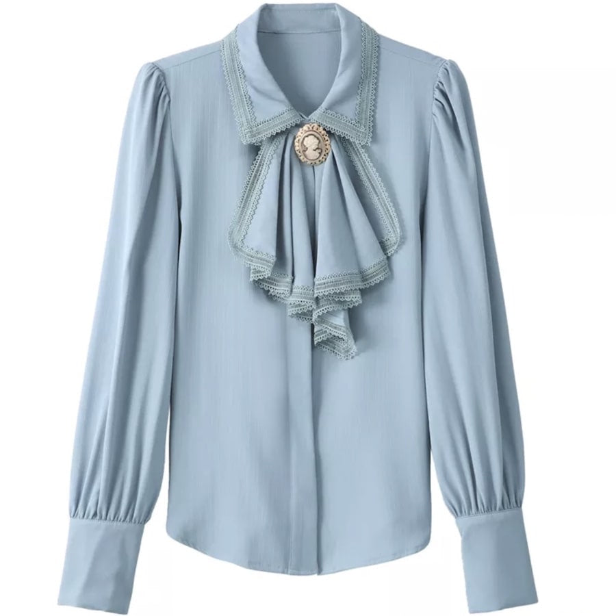 Light blue blouse with ruffles, lace trim, and a cameo.