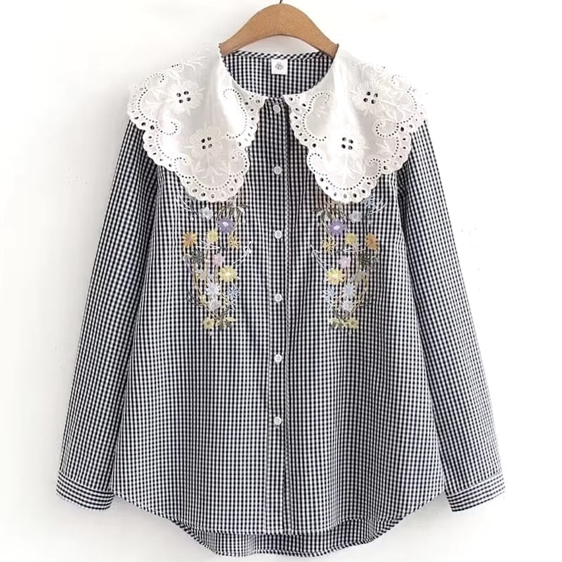 Gingham button-down shirt with eyelet collar and floral embroidery on a hanger.