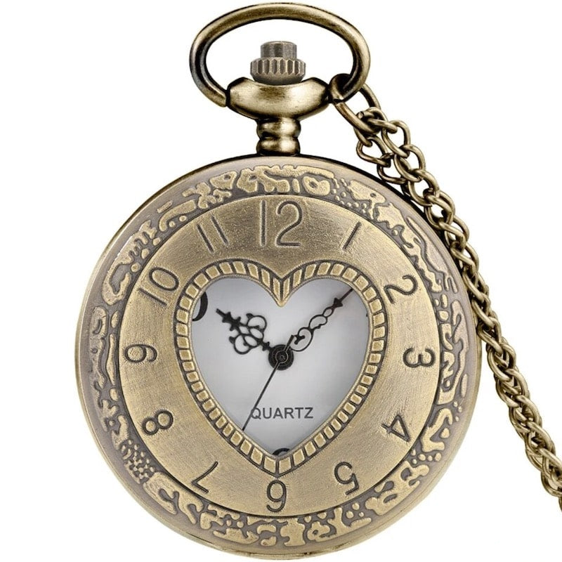 Close-up of a bronze-colored pocket watch with a heart-shaped window.
