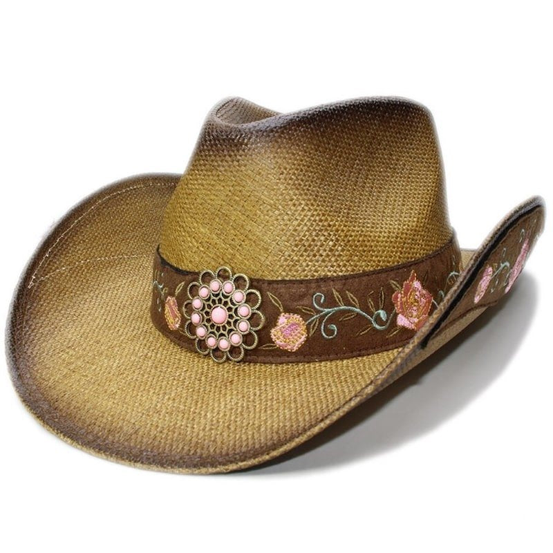 Tan straw cowboy hat with embroidered brown band and floral buckle.
