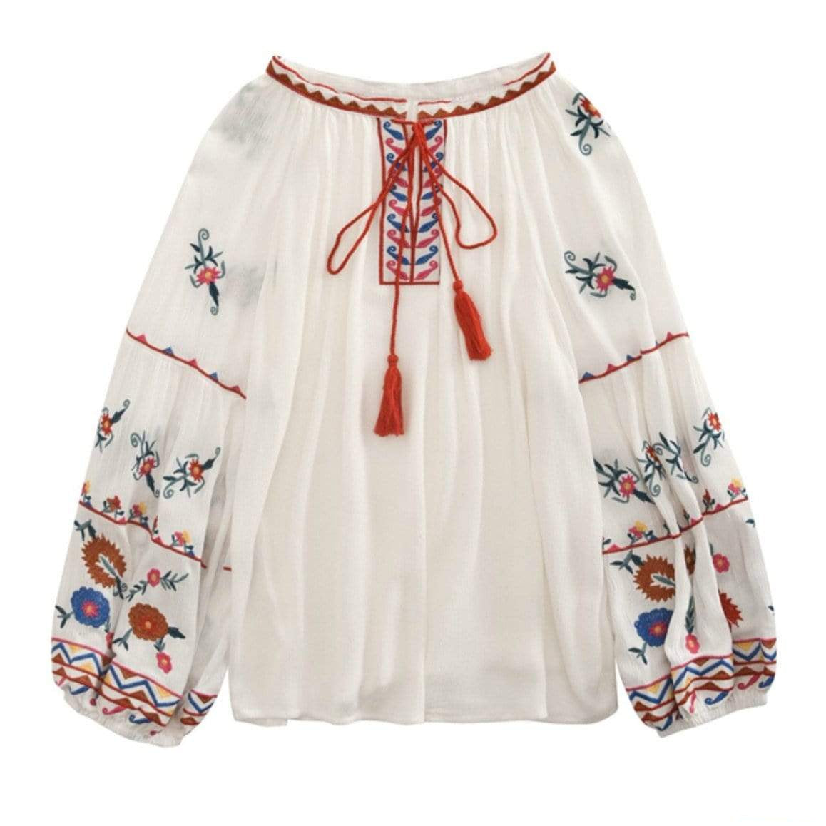 Embroidered white peasant blouse with red tassels.
