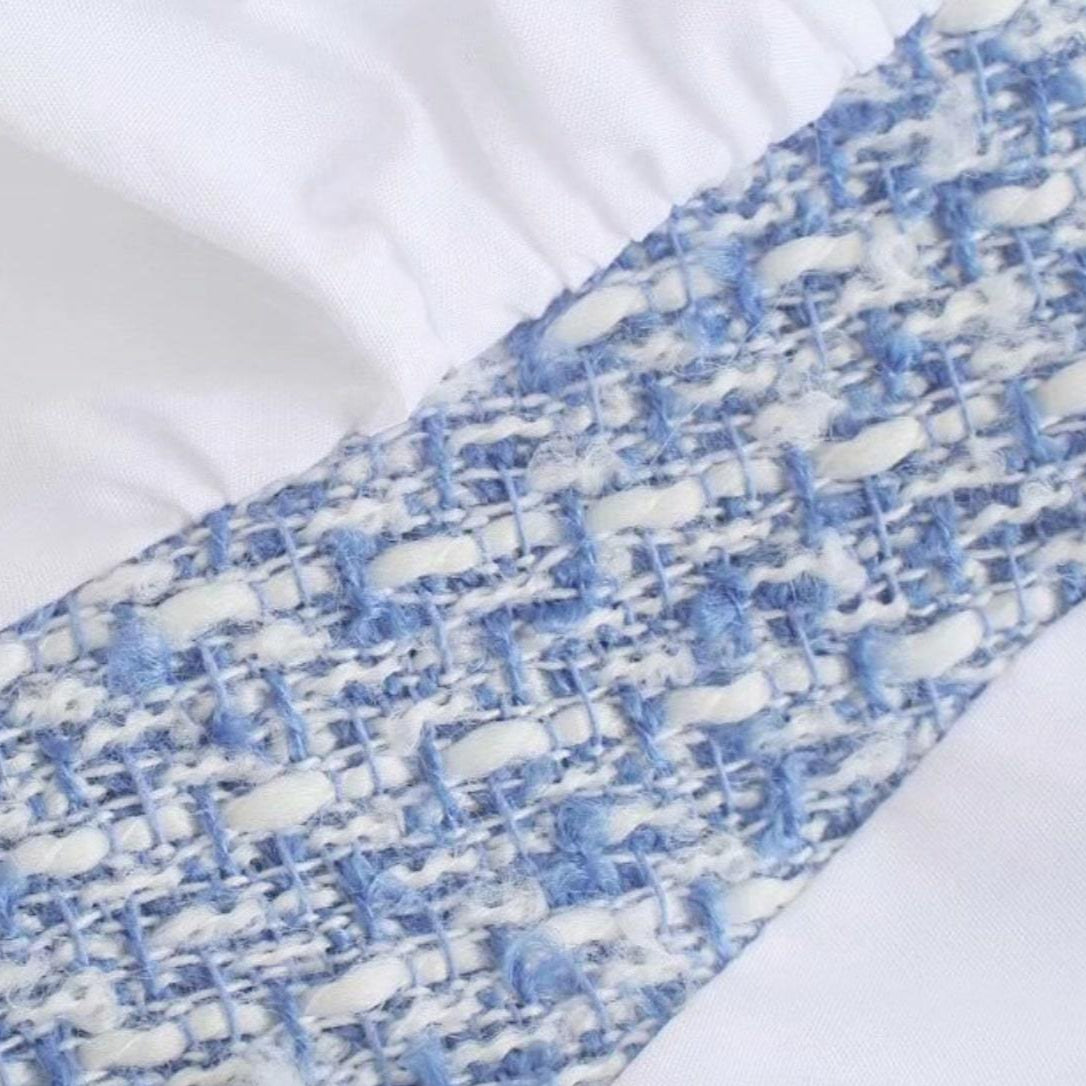Close-up of white and blue woven fabric on white fabric.