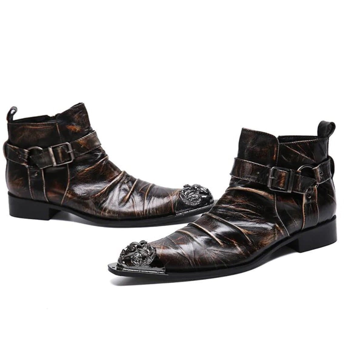 Two brown leather ankle boots with buckle straps and ornate metal toe caps. 
