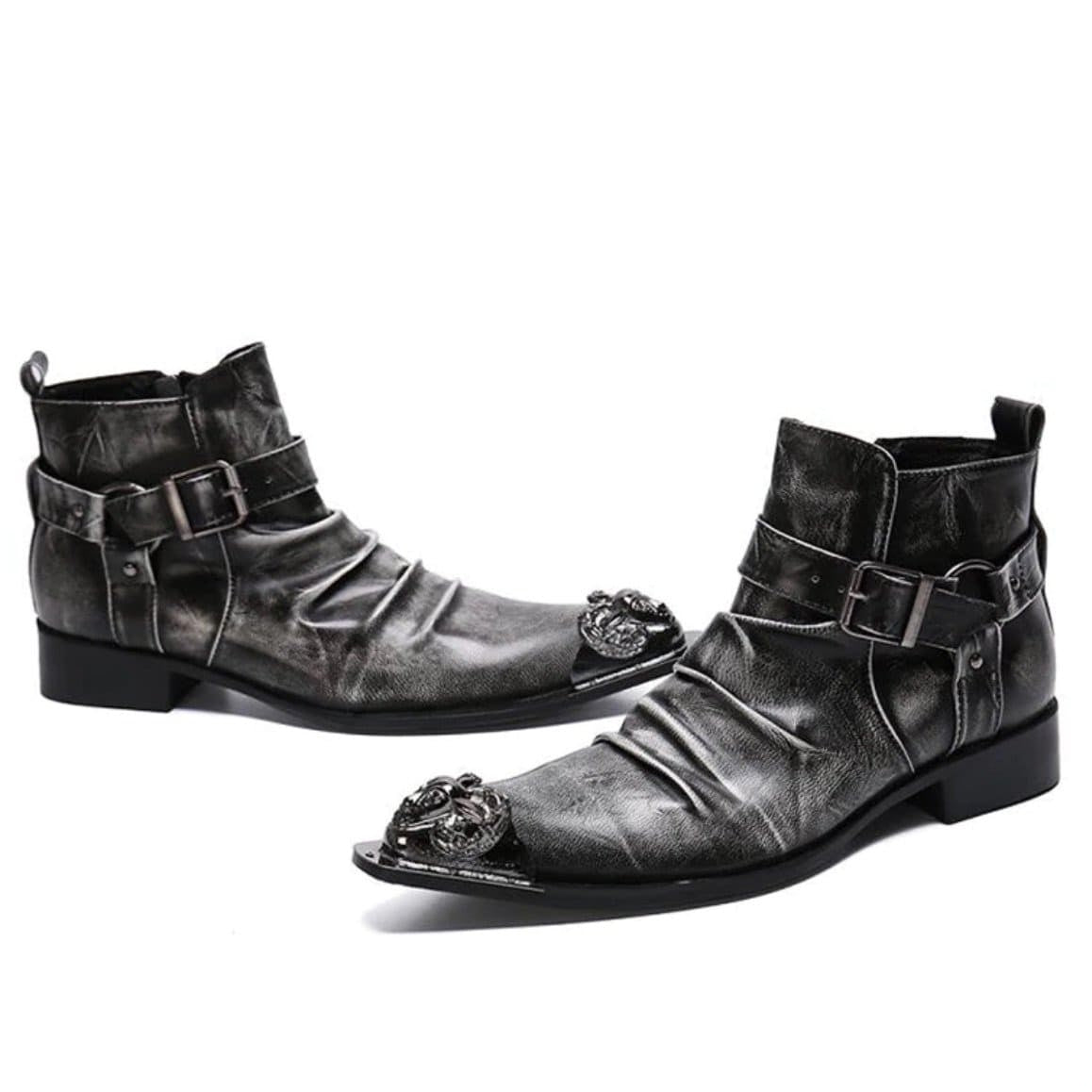 A pair of distressed gray leather ankle boots with decorative metal toe caps and buckle straps.

