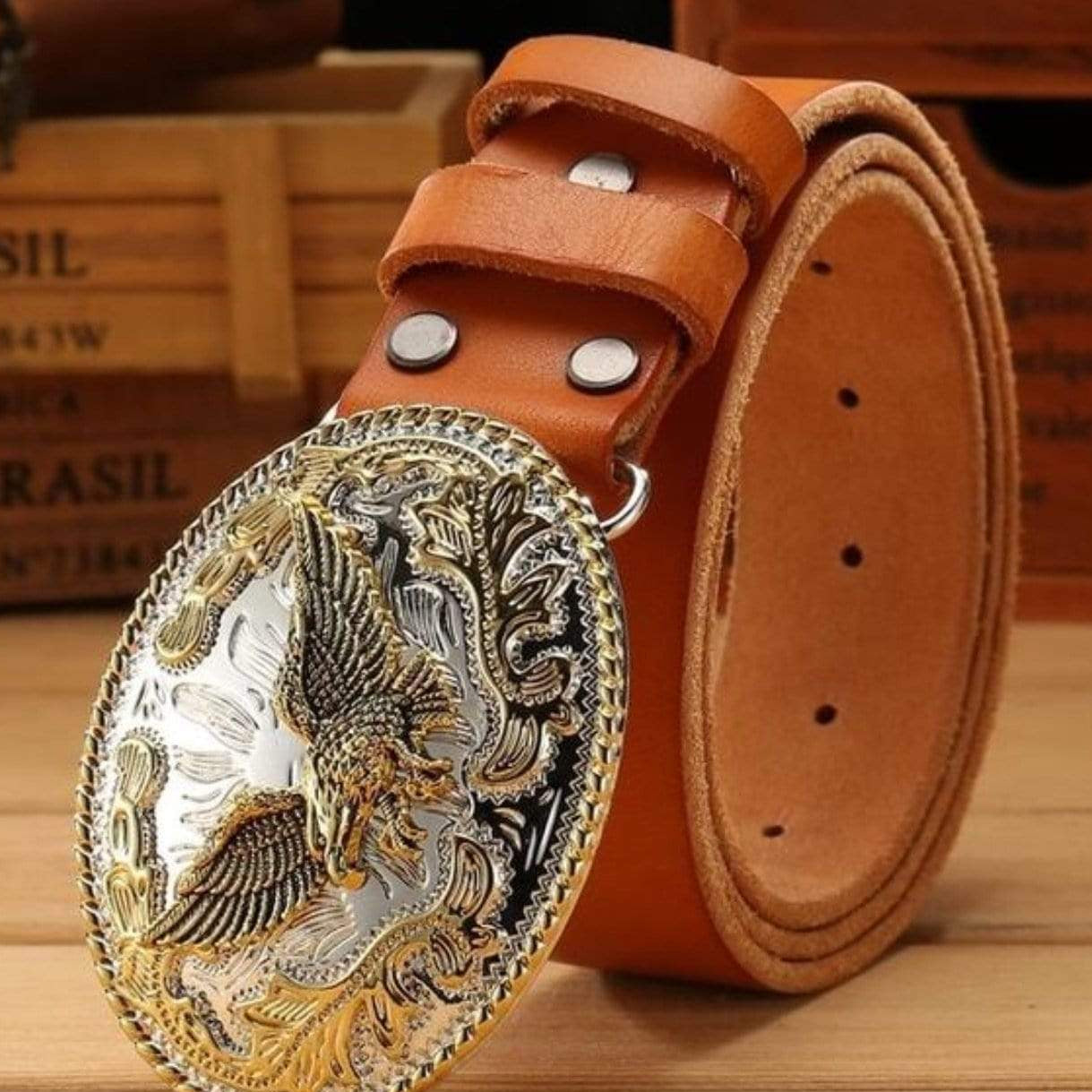 Close-up of a brown leather belt with an ornate silver and gold buckle featuring an eagle design.