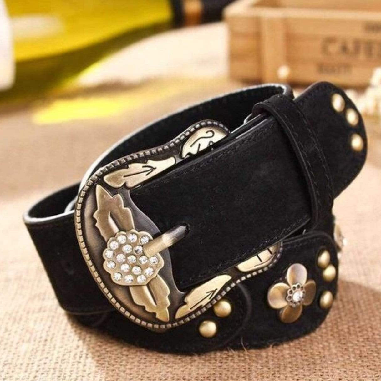 Black suede belt with metal floral buckle.
