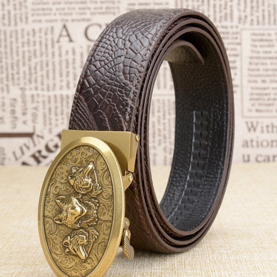 Close-up of a brown leather belt with a gold, oval buckle featuring three wolf heads.