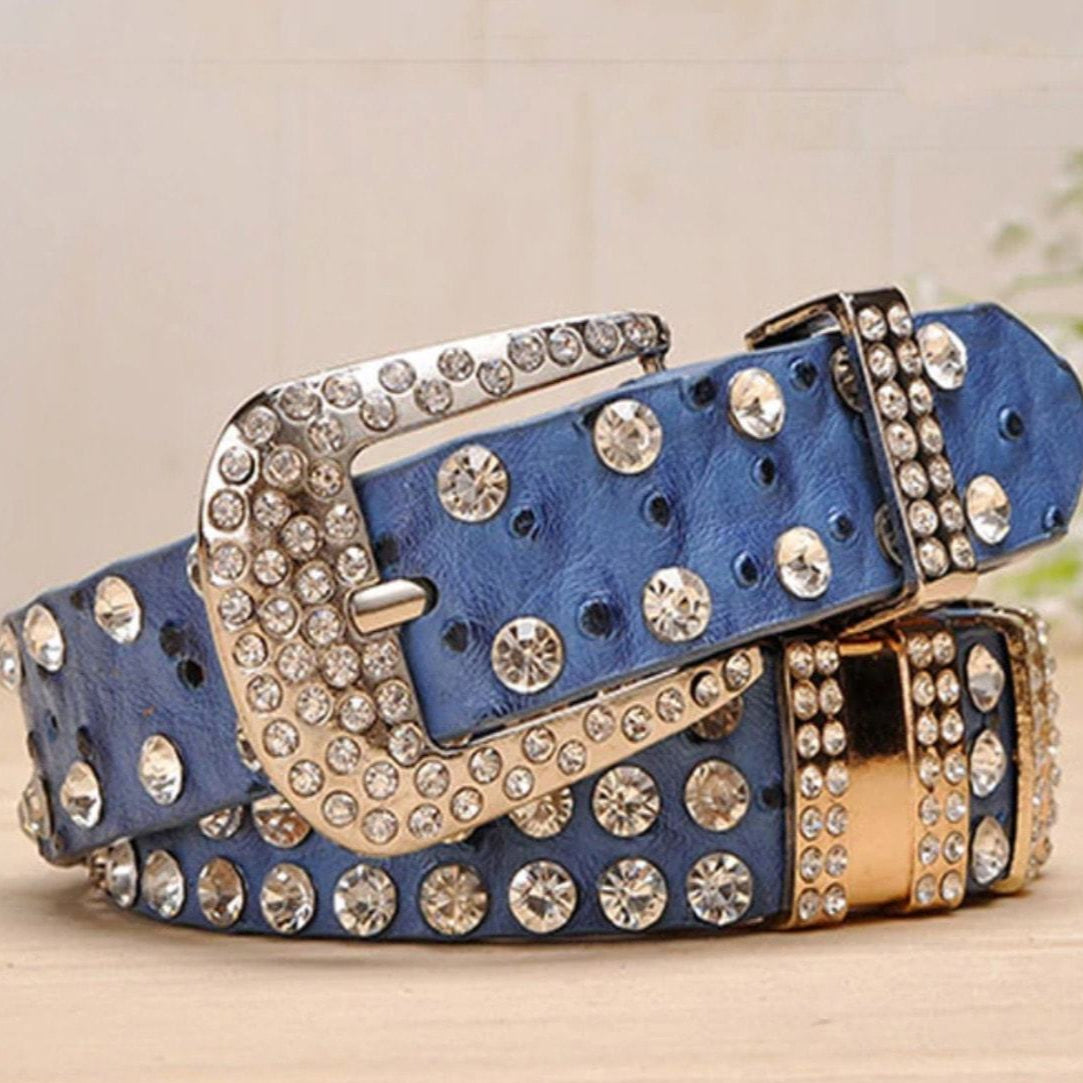 Close-up of a stacked blue leather belt with silver and rhinestone embellishments.