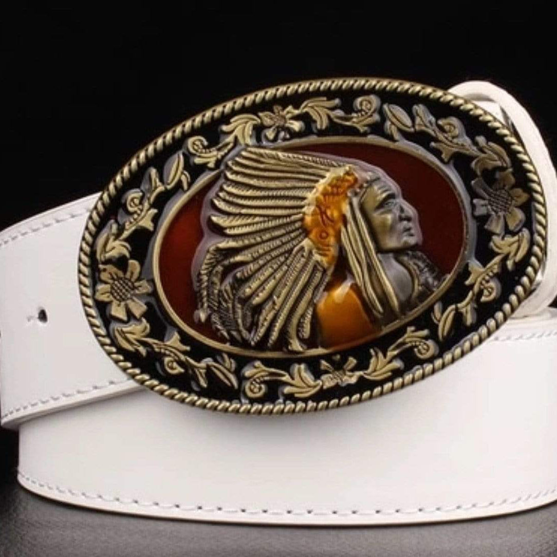 Close-up of a white leather belt with a large, oval-shaped buckle featuring a Native American chief in profile. The buckle is ornate with a bronze-colored border and a red background behind the chief's head.