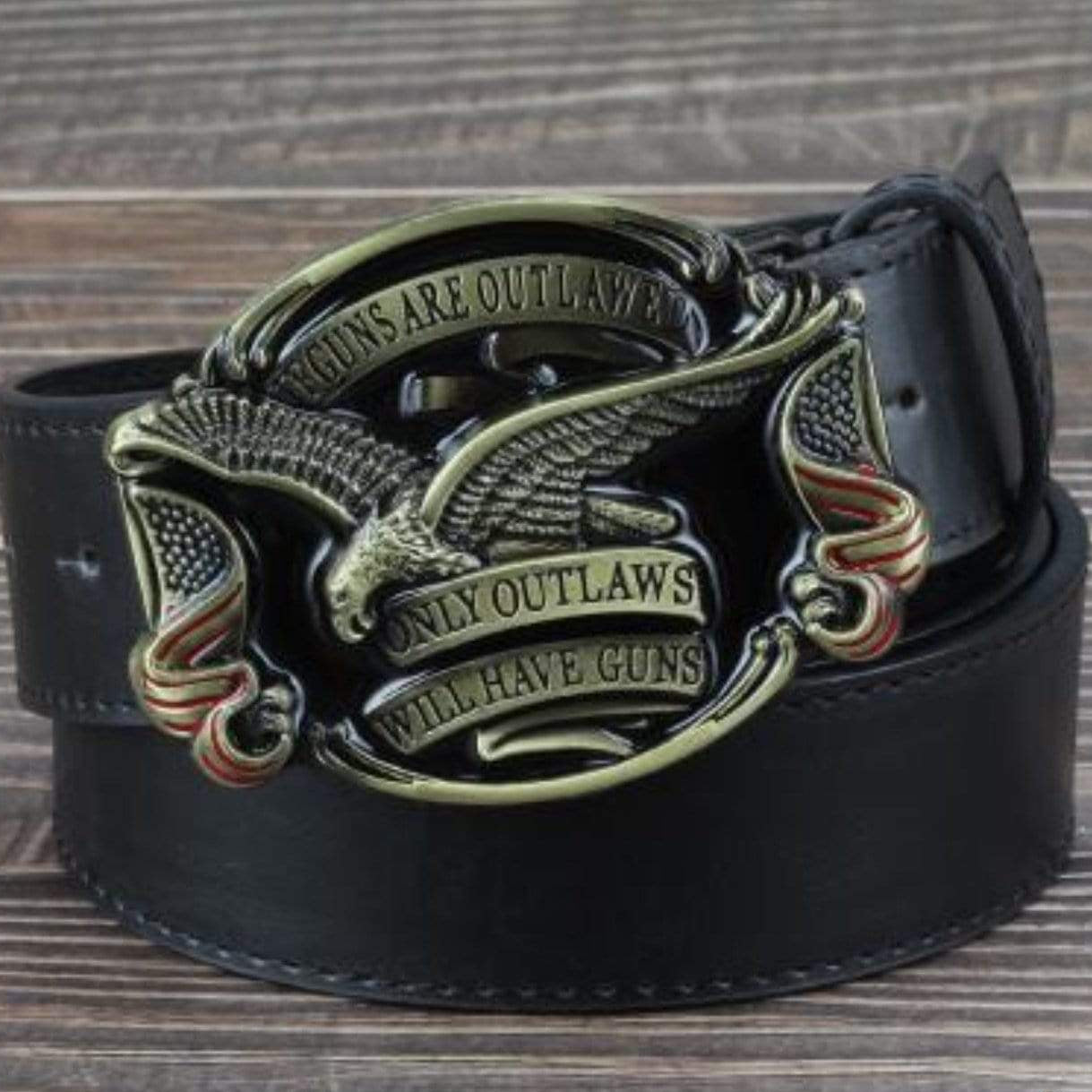 Black leather belt with an ornate gold and silver buckle featuring an eagle and American flags.  The buckle reads: "Guns are outlawed, only outlaws will have guns."
