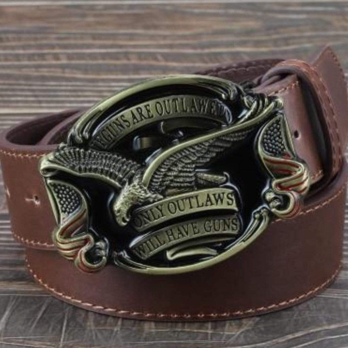 Brown leather belt with an eagle and the text "Guns are outlawed, only outlaws will have guns" on the buckle.
