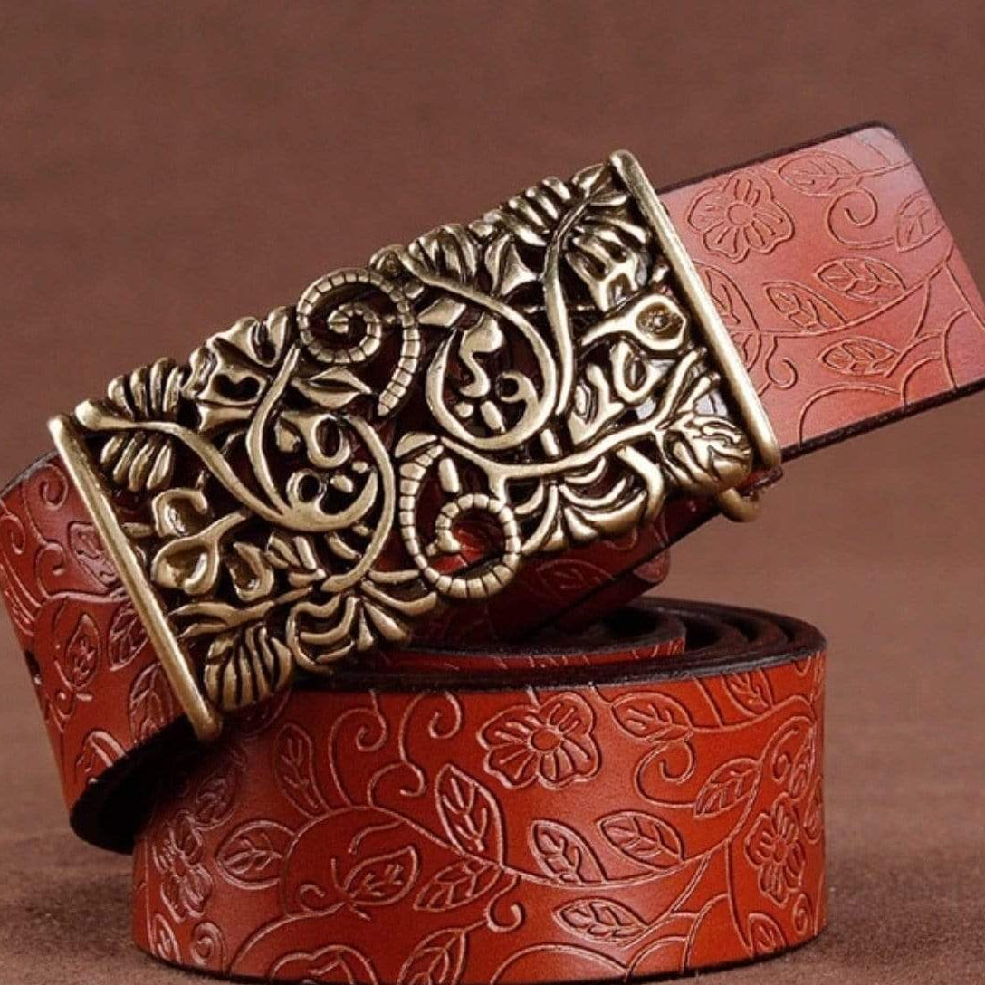 Brown leather belt with floral embossing and ornate gold buckle.
