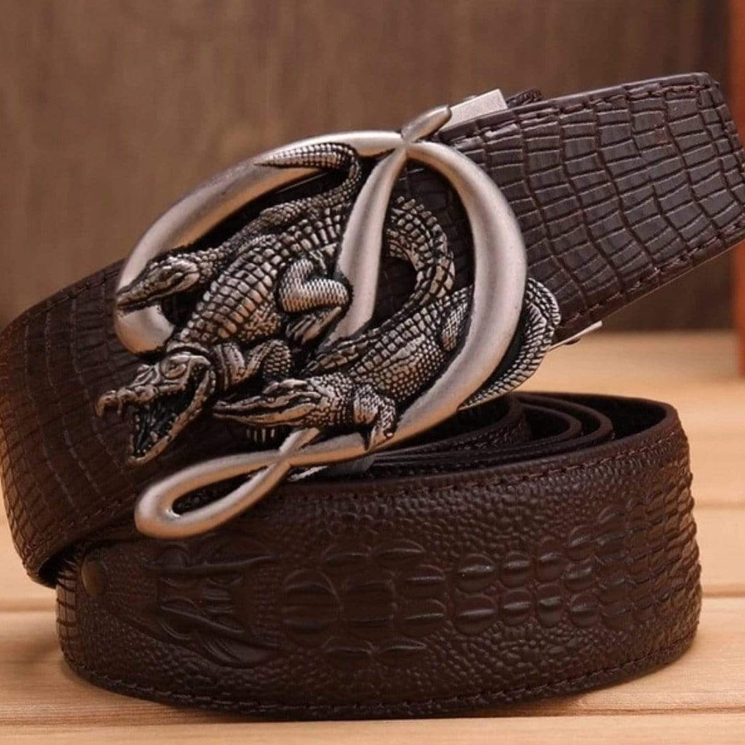 Close-up of a brown alligator-skin belt with a silver buckle featuring three alligators.