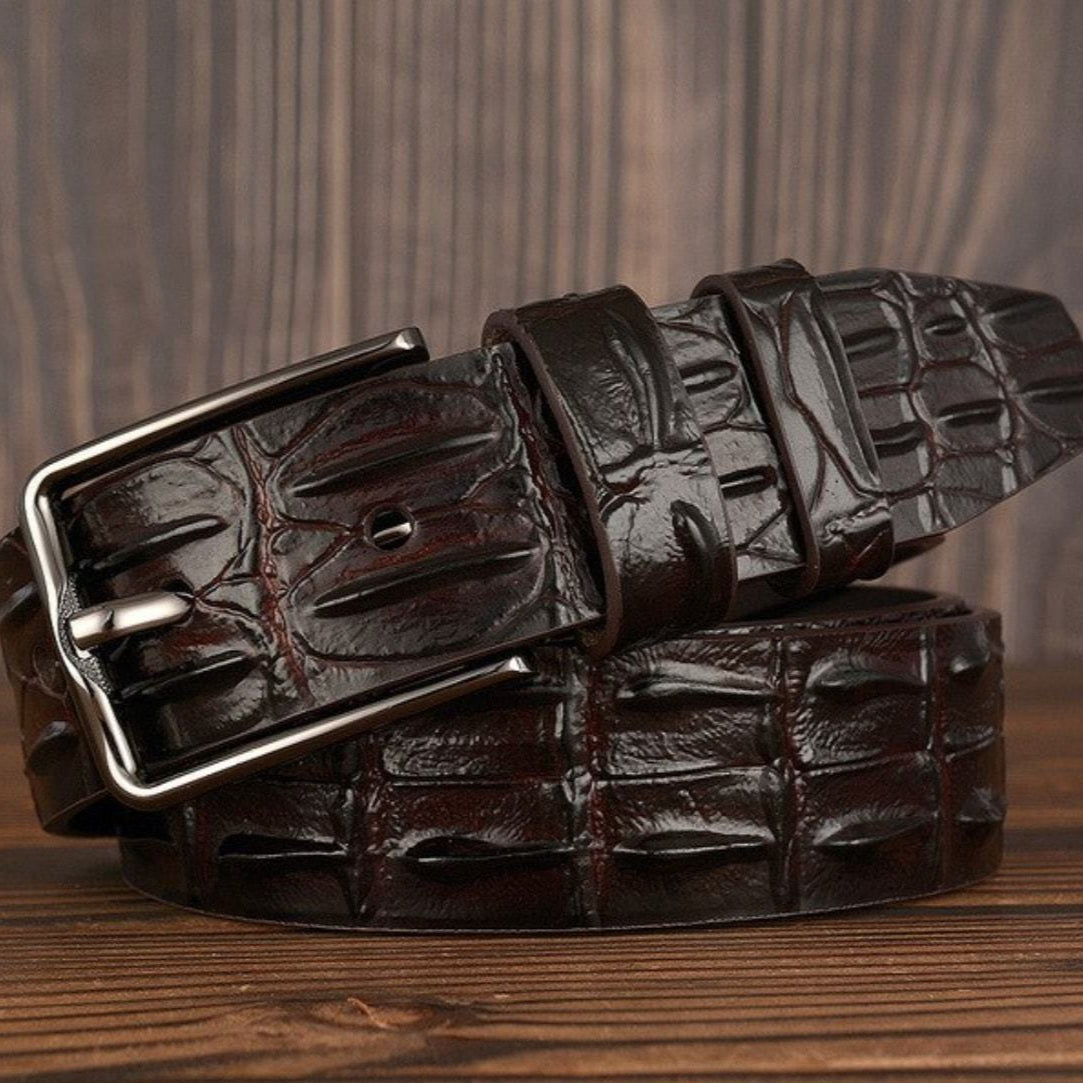 A dark brown leather crocodile belt with a silver buckle.
