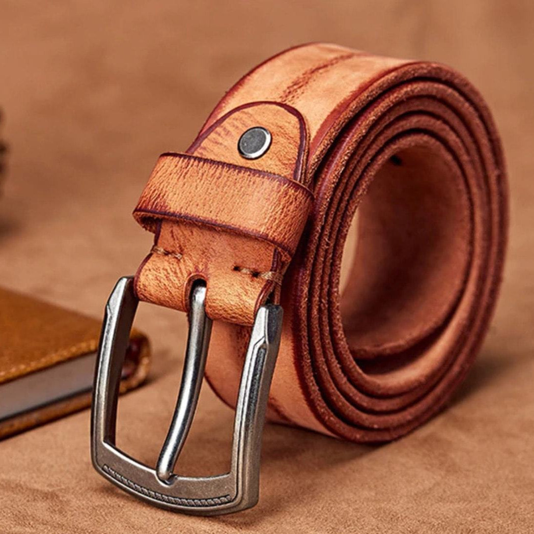 Rolled light brown leather belt with metal buckle.
