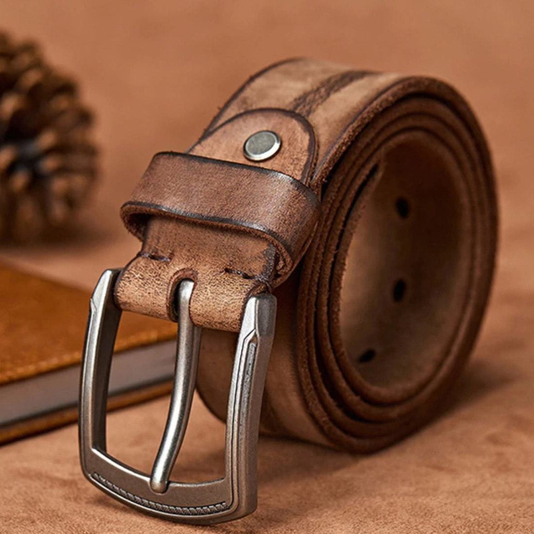 Close-up of a brown leather belt with a silver buckle.