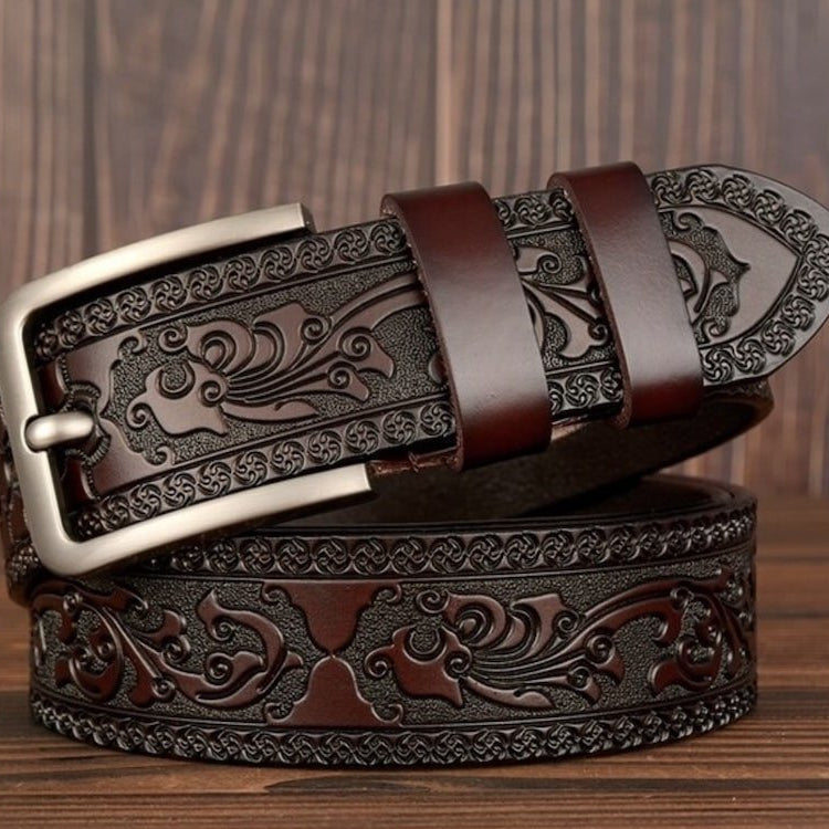 Brown tooled leather belt with a silver buckle.
