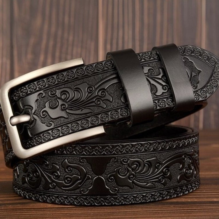 Black leather belt with silver buckle and embossed floral pattern.