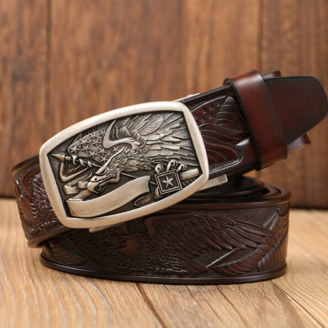 A brown leather belt with a silver buckle featuring an eagle design.