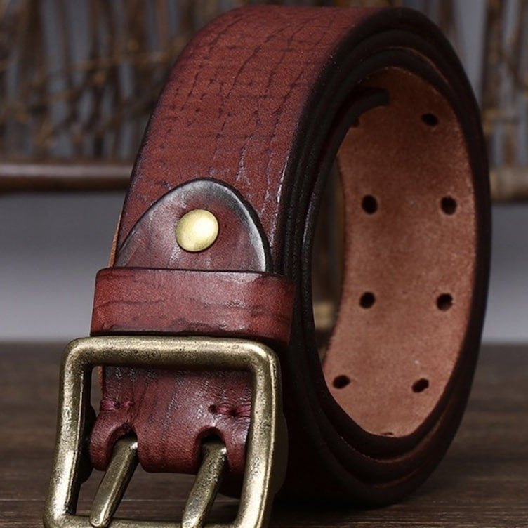 Close-up of a brown leather belt with a brass buckle.
