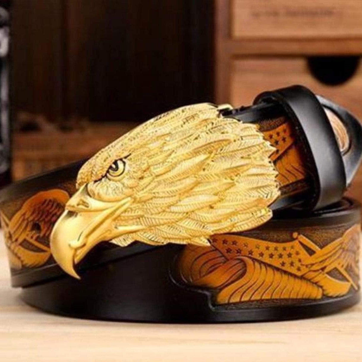 Black and brown leather belt with gold eagle buckle and decorative embossing.