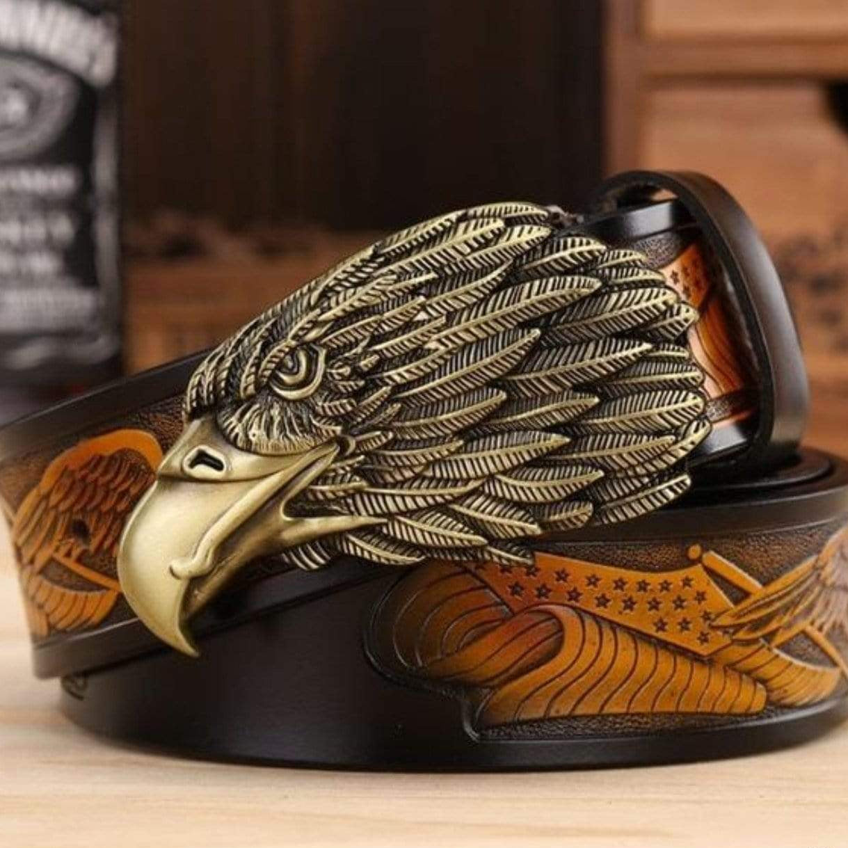 Close-up of a black leather belt with a gold eagle buckle and American flag design.