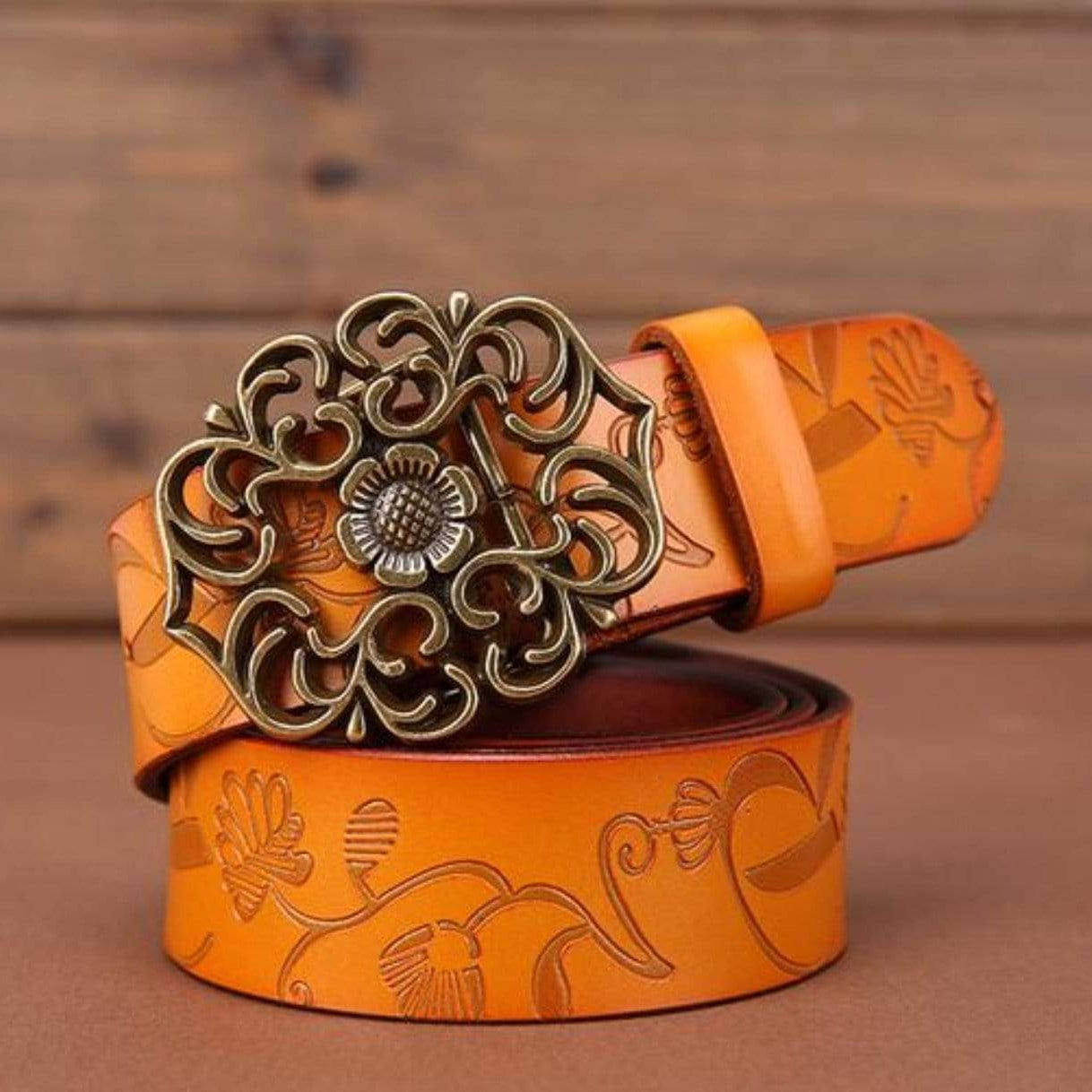 Embossed orange leather belt with bronze buckle.
