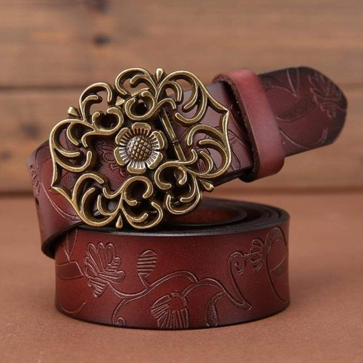 Embossed brown leather belt with ornate gold buckle.
