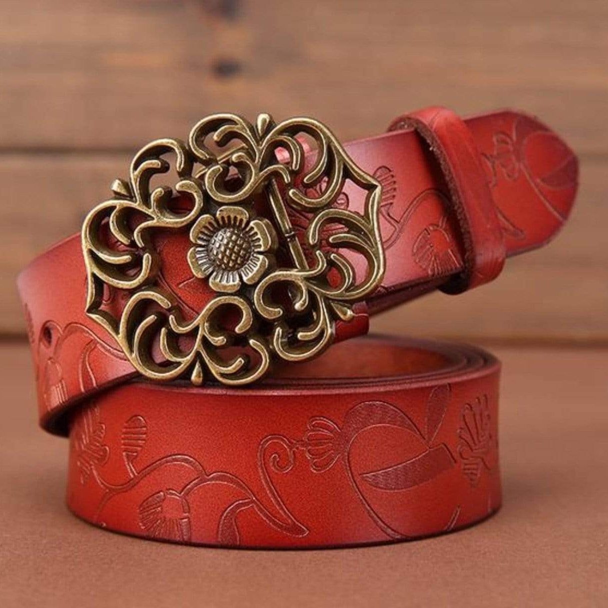 Red embossed leather belt with decorative bronze buckle.