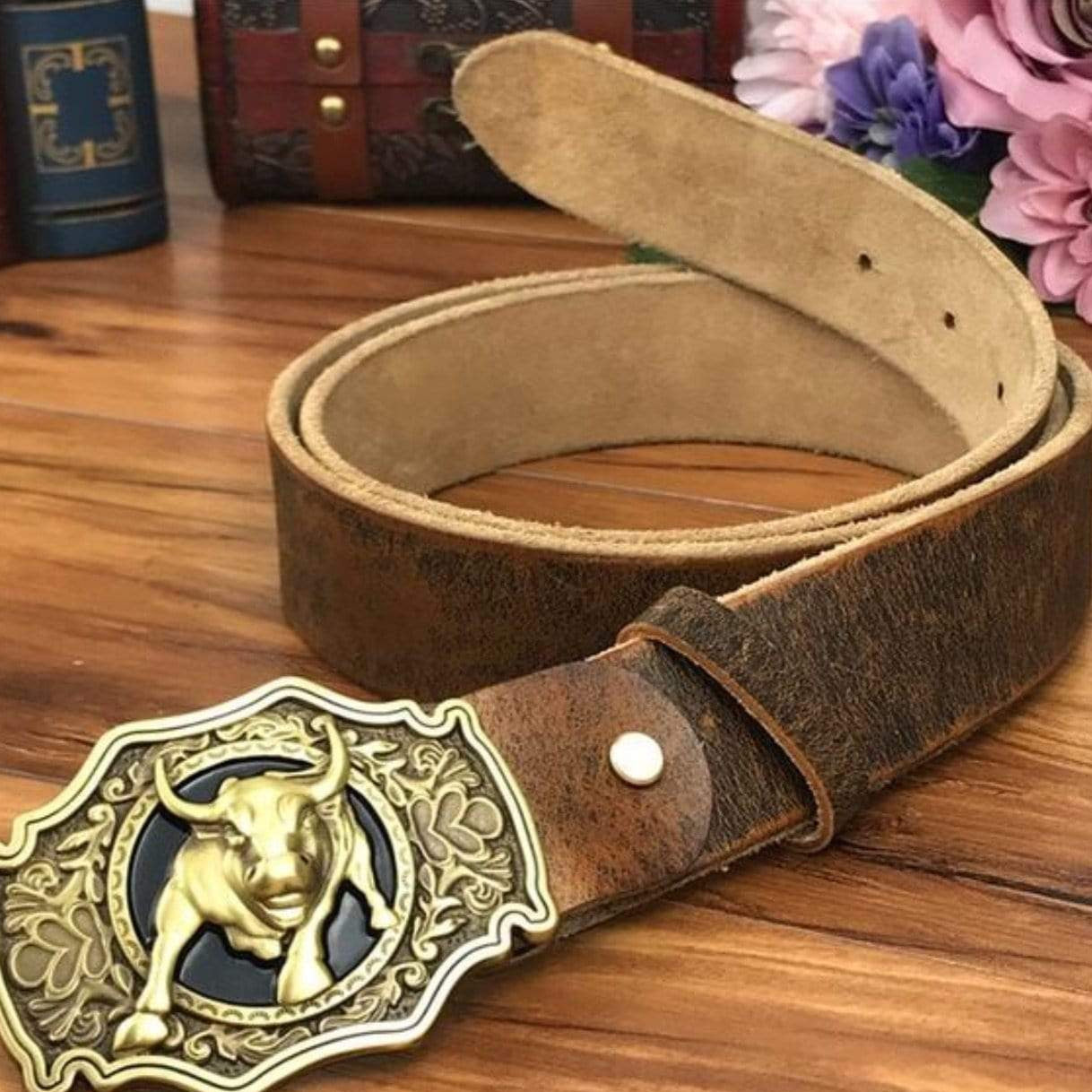 Brown leather belt with a gold bull buckle.
