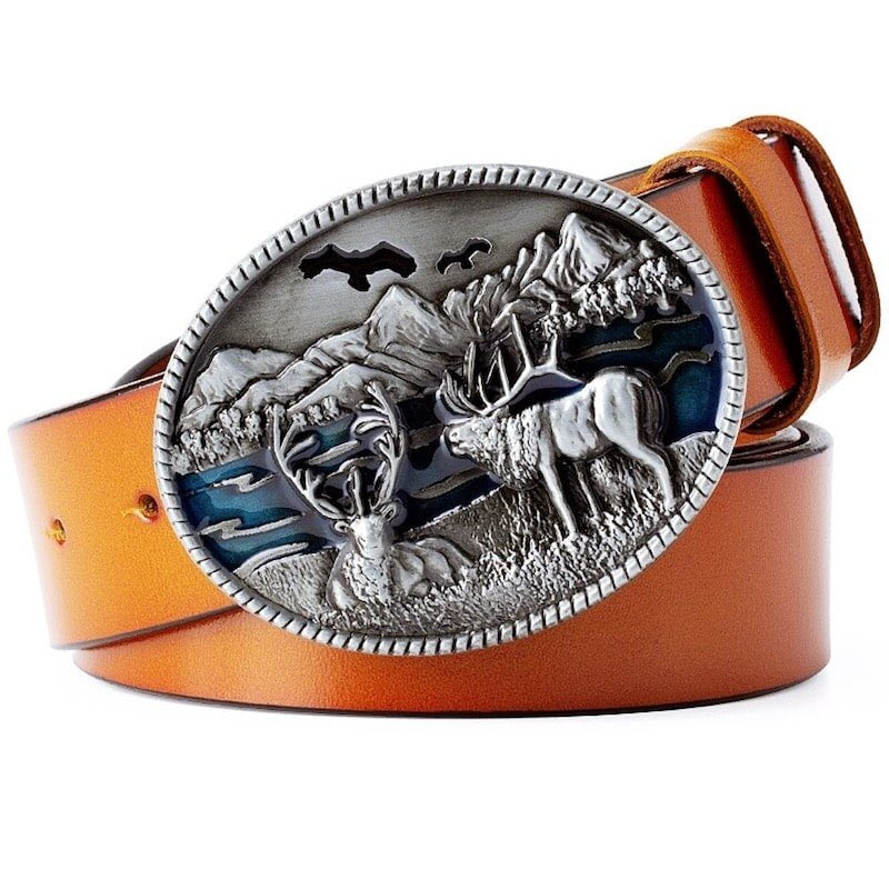 Tan leather belt with large round silver buckle depicting deer and mountains.
