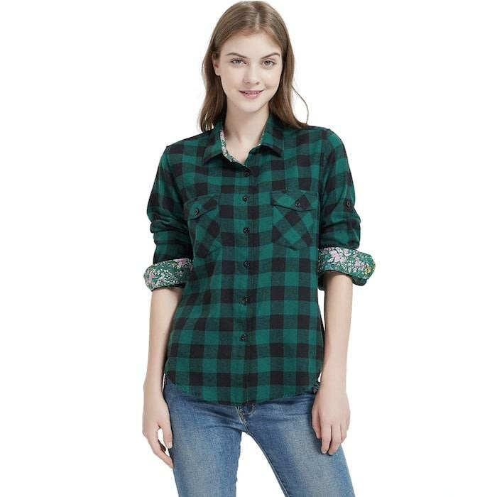A woman in a green and black plaid shirt and blue jeans.