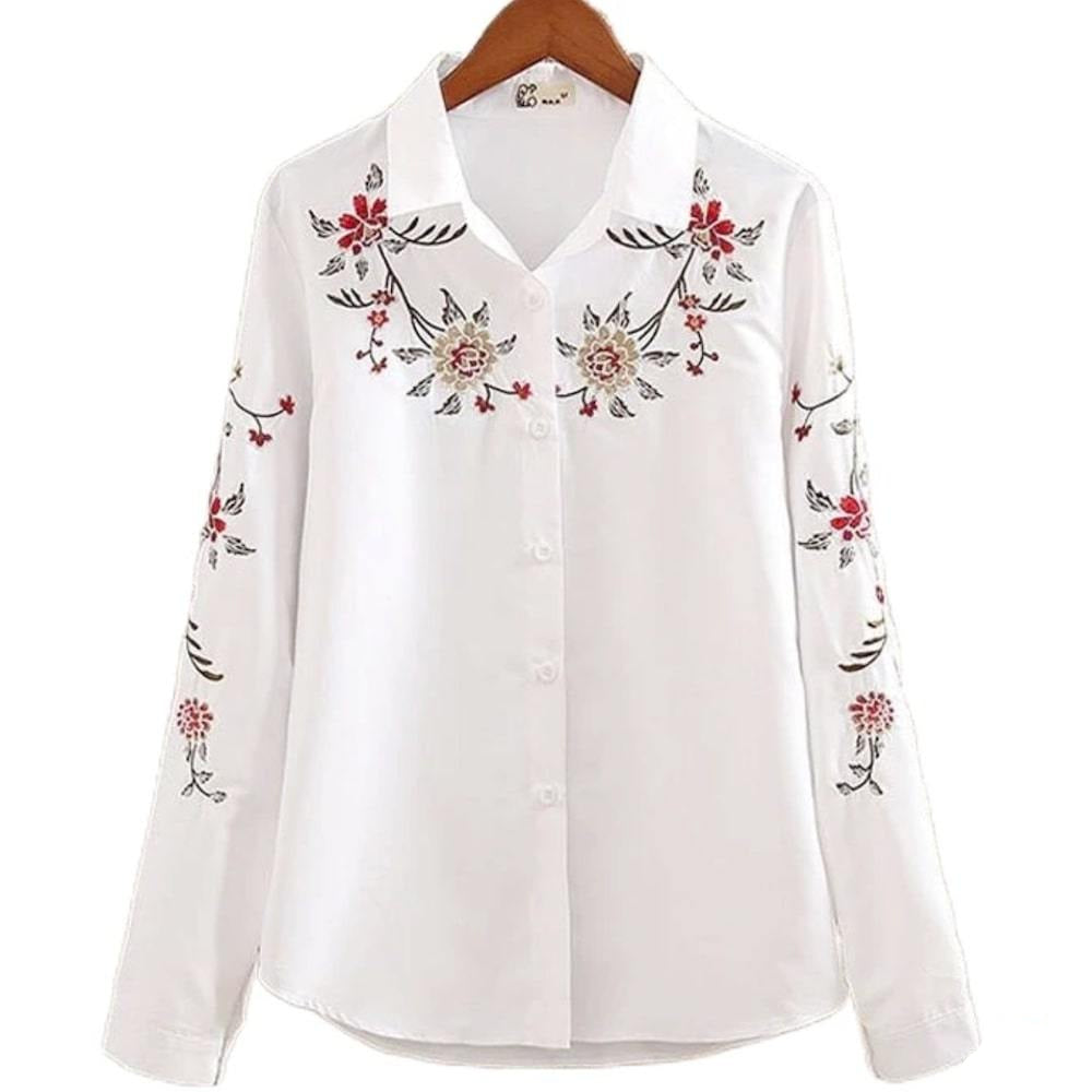 White, embroidered button-down shirt on a hanger.