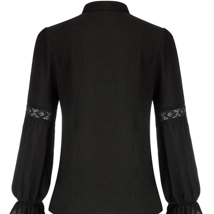 Back view of a long-sleeved black blouse with lace and ruffled cuffs.