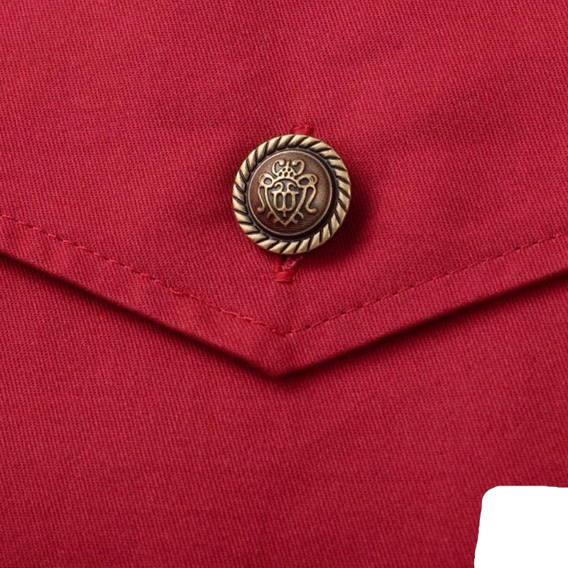 Close-up of a red fabric garment with a decorative, antique-style button.