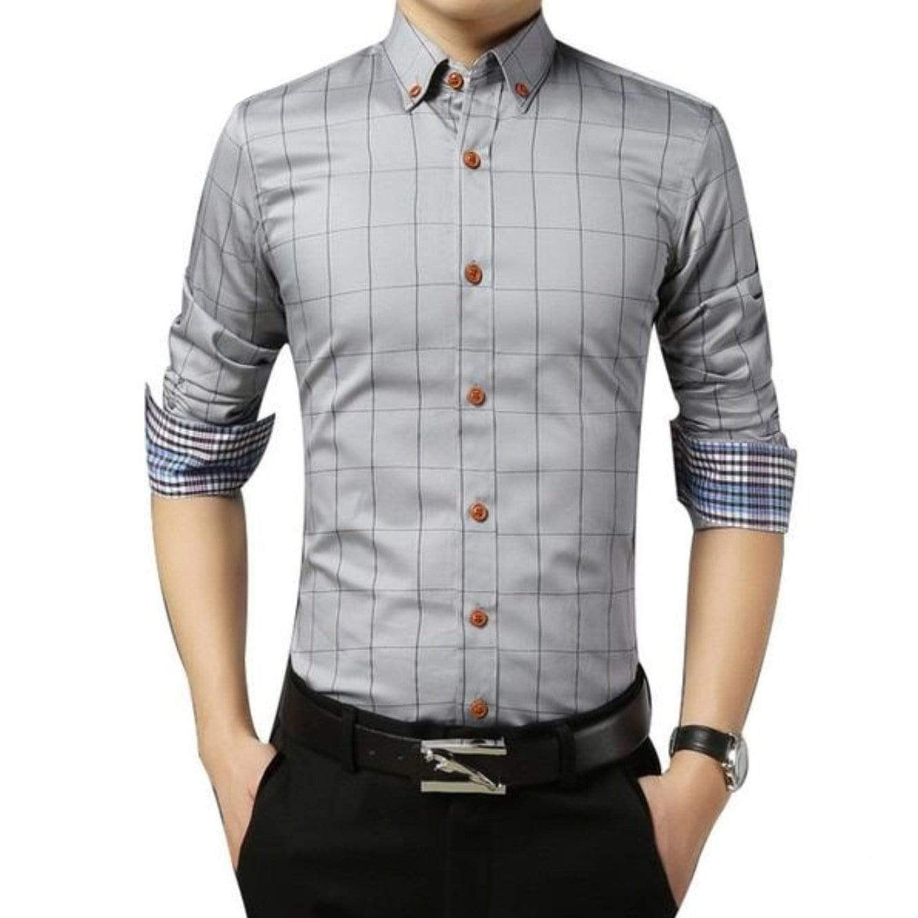 A man wearing a gray plaid shirt with brown buttons, a black belt, and a watch.