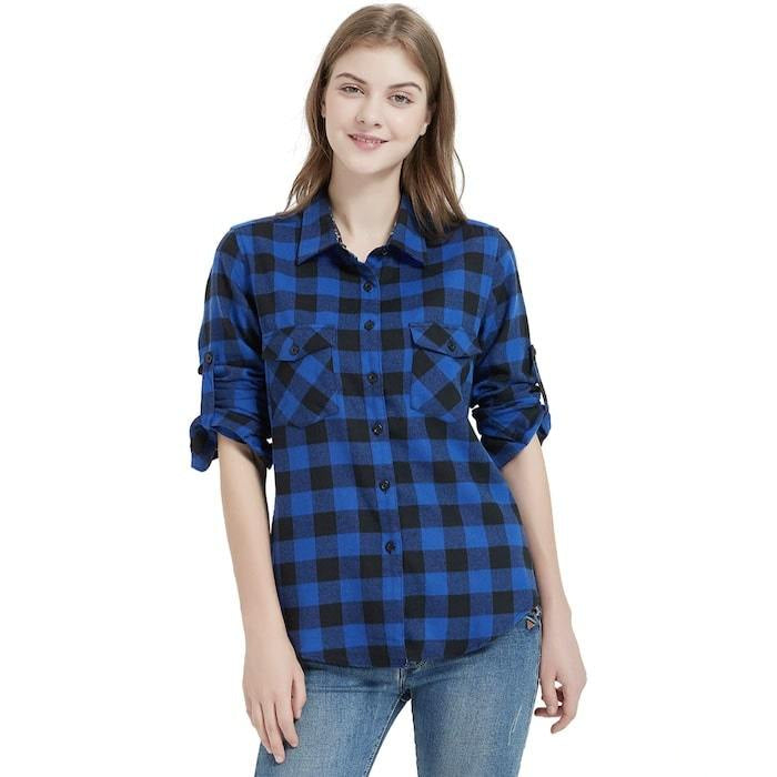 A woman wearing a blue and black flannel shirt and jeans.