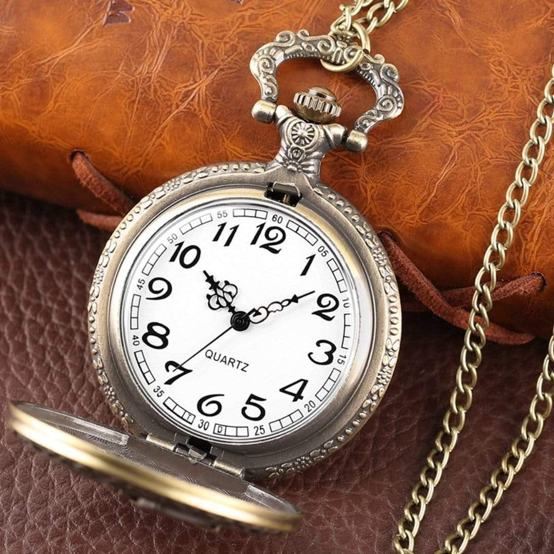 Antique-looking pocket watch with white face and gold chain.
