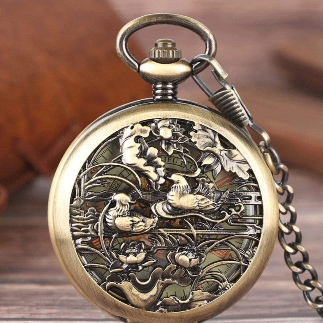 Vintage bronze-colored pocket watch with ducks and floral design.