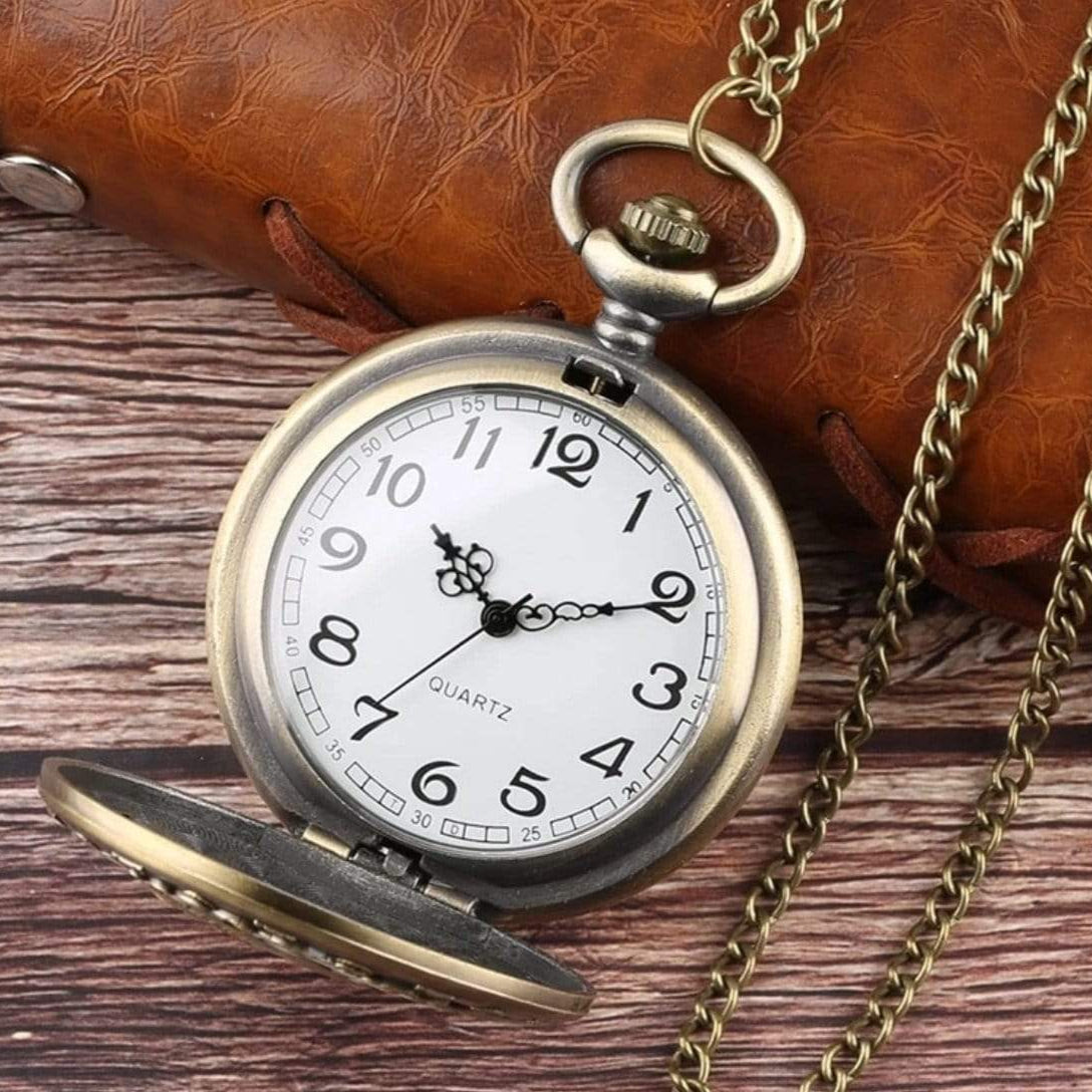 Antique-looking pocket watch with chain and open cover on wooden surface.

