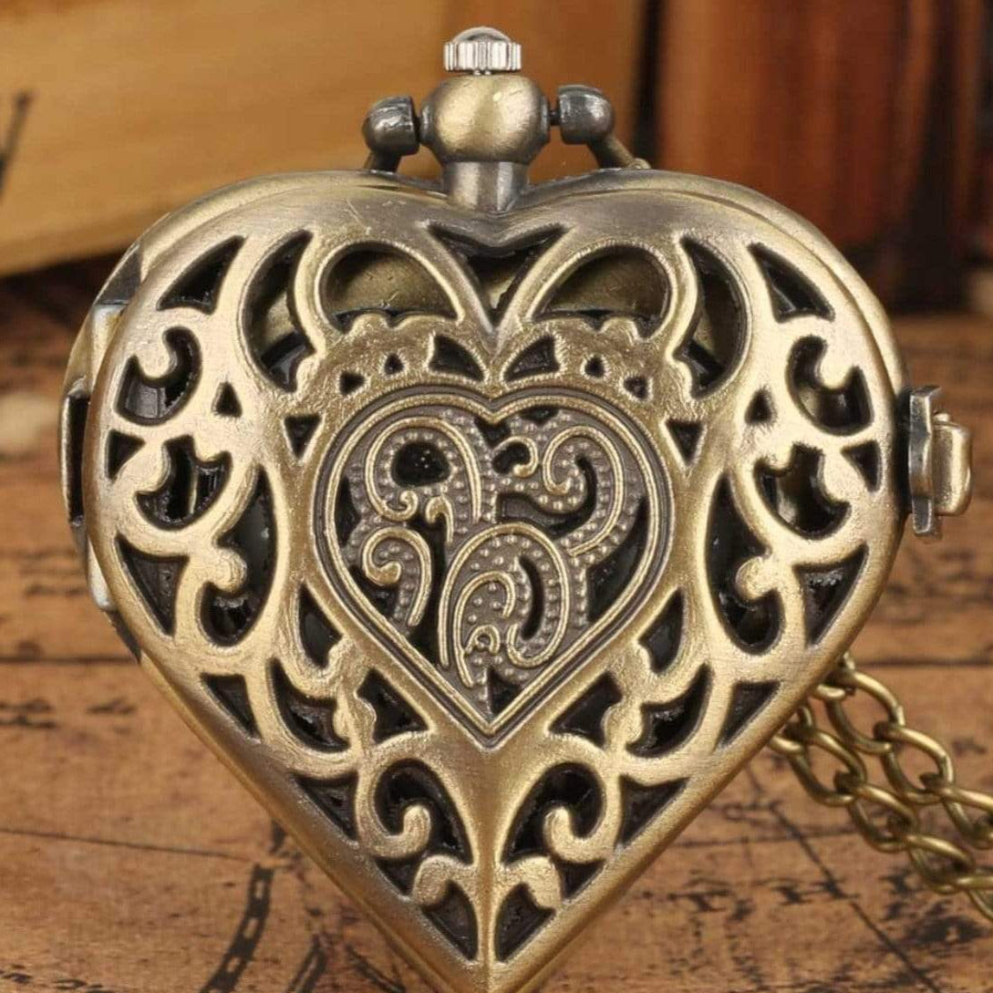 Heart-shaped, filigree-detailed bronze locket with chain. 
