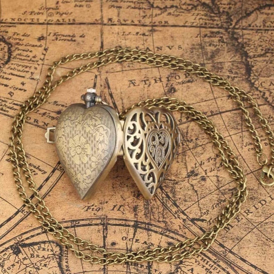Open antique heart-shaped locket pendant necklace on map background.